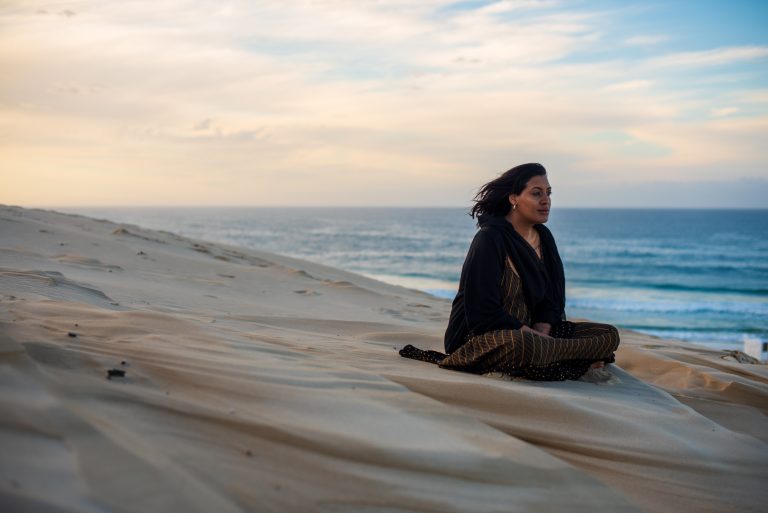 Woman sitting and contemplating at the beach
